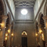 Inside the Duomo: banded columns rising to a lit oculus.